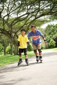 Father and son roller blading in park - Alex Microstock02