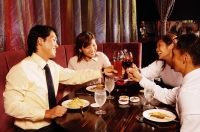 Couples sitting at restaurant, toasting with drinks across table - Alex Microstock02