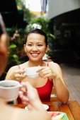 Woman holding cup, smiling, over the shoulder view - Alex Microstock02