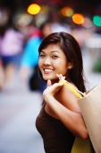 Young woman looking at camera, carrying shopping bag - Alex Microstock02