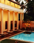 Exterior of building with garden and pool at night - Martin Westlake