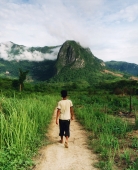 Laotian guide walking along country path in hilltribe country - Martin Westlake