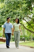 Couple holding hands and walking, man carrying picnic basket - Alex Microstock02