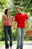 Couple walking in park, man carrying picnic basket - Alex Microstock02