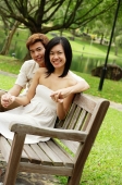 Couple sitting on park bench, looking at camera - Alex Microstock02
