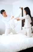 Couple on bed, having a pillow fight - Alex Microstock02