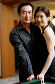 Couple standing cheek to cheek, smiling at camera - Wang Leng