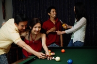 Man teaching woman to play snooker, people in the background - Alex Microstock02
