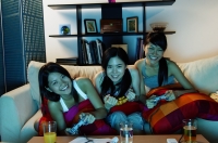 Three young women in living room, playing video games - Alex Microstock02