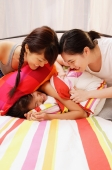 Two women covering another woman with pillows - Alex Microstock02