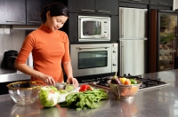 Woman cutting vegetables in kitchen, portrait - Alex Microstock02