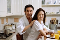 Couple sitting in kitchen, smiling at camera - Alex Microstock02