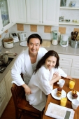 Couple sitting in kitchen, smiling at camera, high angle view - Alex Microstock02