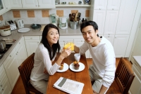 Couple in kitchen, having breakfast, smiling at camera - Alex Microstock02
