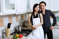 Couple standing in kitchen, smiling at camera - Alex Microstock02