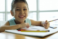 Young girl holding pencil, smiling at camera - Alex Microstock02