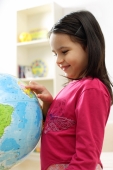 Young girl standing and looking at globe - Alex Microstock02