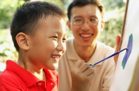 Boy painting on easel, father next to him, smiling - Alex Microstock02