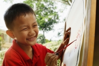 Boy painting on easel, smiling - Alex Microstock02