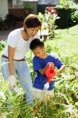 Mother and son watering plants in garden - Alex Microstock02