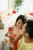 Couple standing in living room, holding drinks - Alex Microstock02