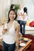Woman holding wine glass, looking at camera, people in the background - Alex Microstock02