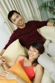 Couple in living room, woman lying on mans lap, smiling at camera - Alex Microstock02