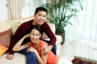 Couple in living room, smiling at camera, portrait - Alex Microstock02