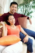 Couple in living room, sitting on sofa, smiling at camera, portrait - Alex Microstock02