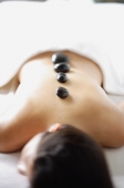 Woman lying down with stones on her back - Alex Microstock02
