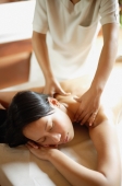 Young woman being massaged by therapist - Alex Mares-Manton