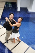 Couple dancing by swimming pool, smiling at camera - Alex Mares-Manton