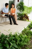 Couple sitting and having coffee on patio - Alex Mares-Manton
