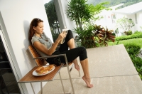 Woman reading book on patio - Alex Mares-Manton