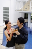 Couple by poolside, toasting with champagne - Alex Mares-Manton