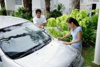 Man washing car and spraying woman with water - Alex Mares-Manton