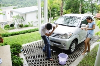 Couple washing car, woman spraying man with water - Alex Mares-Manton