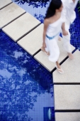 Couple walking across swimming pool - Alex Mares-Manton