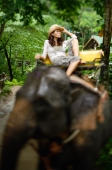 Young woman sitting on top of elephant, Phuket, Thailand - Alex Mares-Manton