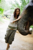 Young woman touching elephant, looking at camera, Phuket, Thailand - Alex Mares-Manton