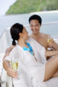 Couple sitting on yacht holding champagne glasses - Alex Mares-Manton