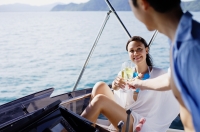 Couple on yacht, toasting with drinks - Alex Mares-Manton