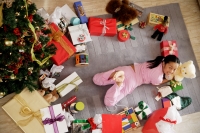 Girl lying on floor, surrounded by gifts, looking at camera - Alex Microstock02