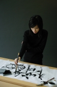 Young woman painting Chinese calligraphy - Wang Leng