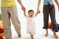 Baby boy walking between his parents - blueduck