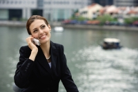 Businesswoman using mobile phone, river in the background - Alex Microstock02