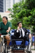 Businessman on trishaw, using mobile phone - Alex Microstock02