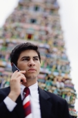 Businessman using mobile phone, Hindu temple in the background - Alex Microstock02