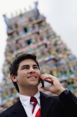 Businessman with mobile phone, Hindu temple in the background - Alex Microstock02