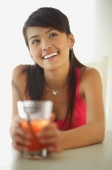 Woman sitting at table, holding drink, looking away, smiling - Alex Microstock02